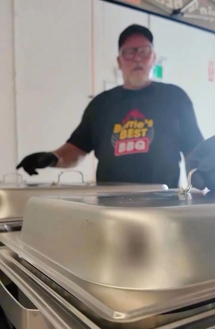 Aaron in a Barrie’s Best BBQ shirt behind a row of covered chafing dishes